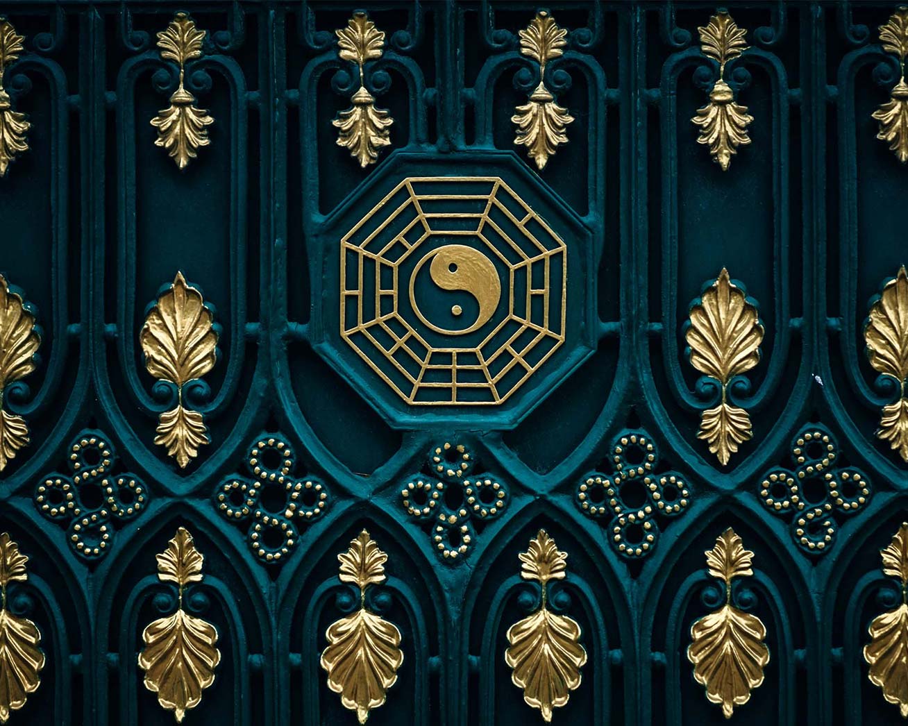 A gold and blue doorway with yin yang symbols leading into a Taoist temple