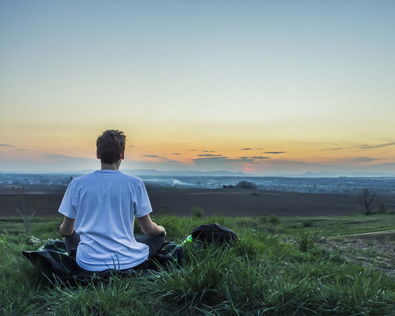 Healing Tao Center by Mantak Chia - Healing Tao Australia. A man meditating and doing qigong on a hill at sunrise