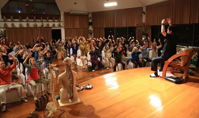 Master Mantak Chia teaching a group of people how to do energy work
